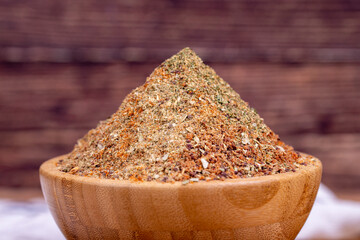 Mixed spice. Spices prepared with a mixture of mint, fenugreek flour, ground pepper, poyotu, thyme, sumac, coriander powder, paprika on wooden background. Mixed spices in wooden bowl. Close up