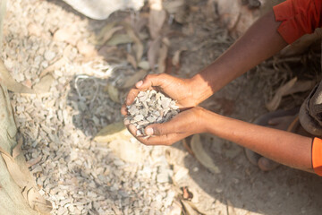 A man holds many bricks and stones in his fists
