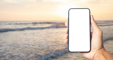 Hand holding black smartphone with transparent screen  and sea at sunset   background , PNG file smartphone frameless application design concept.