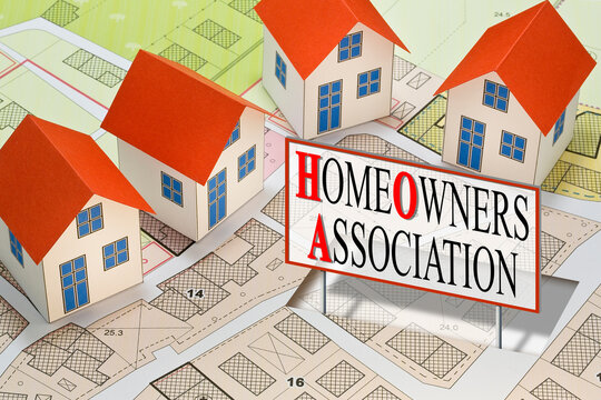 Homeowner Association concept with residential homes models against an imaginary city map and text