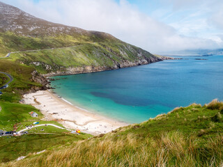 Keem bay and beach and Cliffs, Achill island, County Mayo, Ireland. Popular travel area with stunning nature scenery. Warm sunny day, cloudy sky. Irish tourism. Beautiful ocean view.