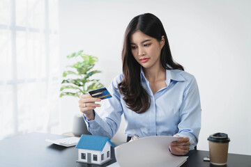 Asian woman depressed while checking bank account balance and credit card bills payment, Income is not enough for expenses.