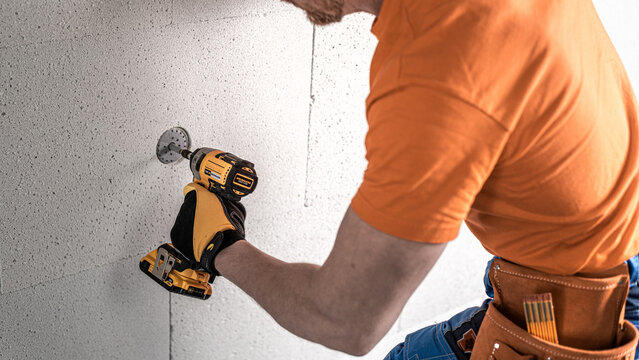 Screwing a dowel for thermal insulation using the aku impact wrench.