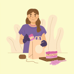 Young woman puts handmade soap into a paper bag.