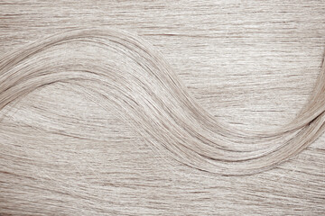 Blond hair close-up as a background. Women's long blonde hair. Beautifully styled wavy shiny curls....
