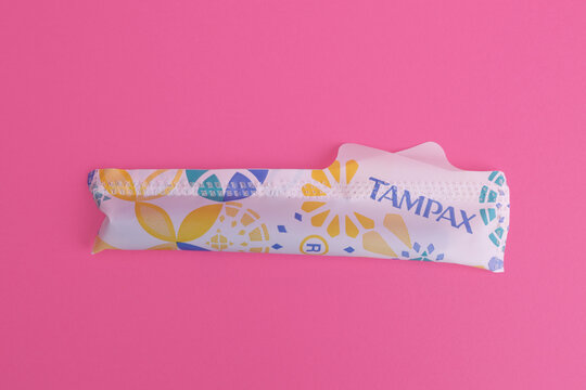 Magdalinovka, Ukraine - June 2, 2023. Tampax tampons in a wrapper on a pink background