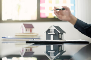 Agents working in real estate investment and home insurance signing contracts in accordance with the home buying insurance agreements approving purchases for clients