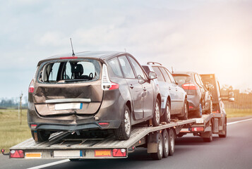 Tow truck with broken car on country road. Tow truck transporting car on the highway. Car service...