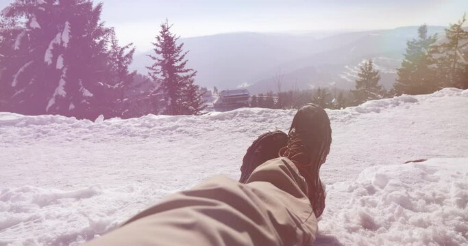 Winter wonderland Amidst the mountains and snow-covered ground, a lone traveler enjoys leisure activities. Perfect landscape for a cold weather vacation with sunbathing at high altitude - sunlight fla