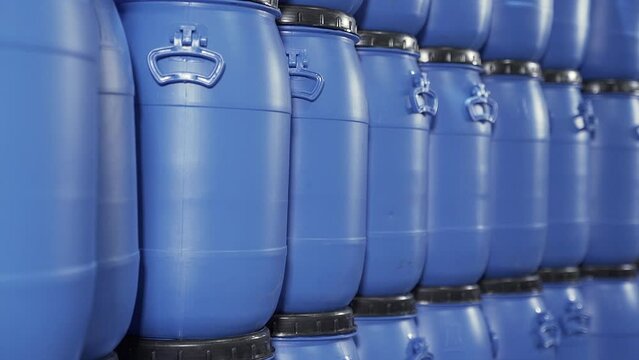 A close up group of Blue stacked Plastic chemical drums or Plastic Chemical barrels in the industrial warehouse.