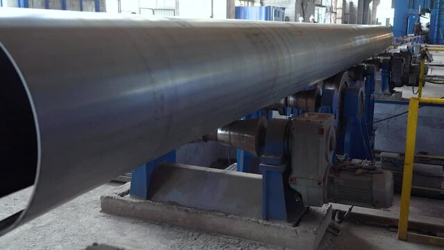 Pipe manufacturing plant. Pipe plant. Iron pipe welding. Pipe expansion. Sparks of welding. Tap. Factory. Machine tools. Production. Heavy industry.