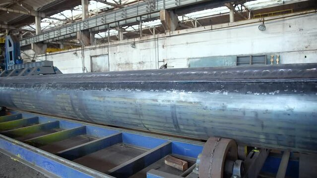 Pipe manufacturing plant. Pipe plant. Iron pipe welding. Pipe expansion. Sparks of welding. Tap. Factory. Machine tools. Production. Heavy industry.