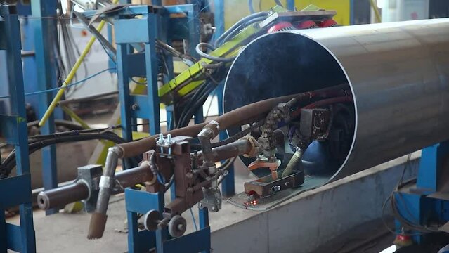 Pipe manufacturing plant. Pipe plant. Iron pipe welding. Pipe expansion. Sparks of welding. Tap. Factory. Machine tools. Production. Heavy industry.