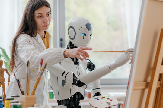 Woman teaching painting to a robot