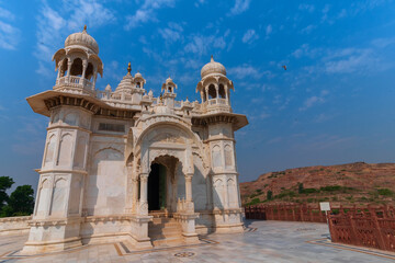 Obraz premium Beautiful architecture of Jaswant Thada cenotaph, Jodhpur, Rajasthan,India. in memory of Maharaja Jaswant Singh II. Makrana marble emitting warm glow when illuminated by the Sun. Blue sky background.