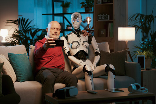 Senior man taking a picture with his humanoid robot
