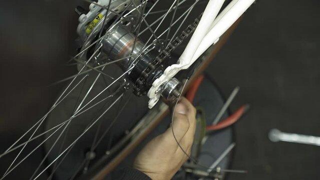 bicycle mechanic tightening rear wheel axle