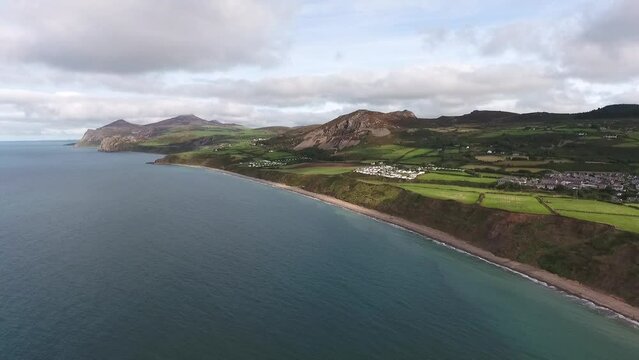Aerial view of long sandy crescent of Nefyn beach on the Llyn Peninsula looking towards the Iron Age Hillfort and Yr Eifl Mountains