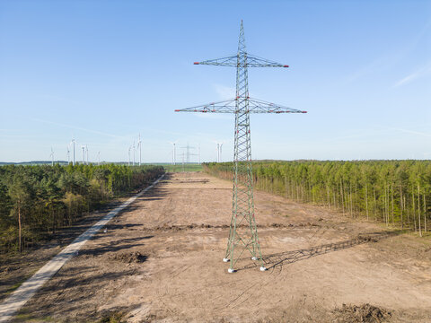 Neue Stomtrasse mit Strommasten für den Transport erneuerbarer Energie aus Windkraft
