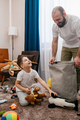 Father and little boy clean up toys - 610948421
