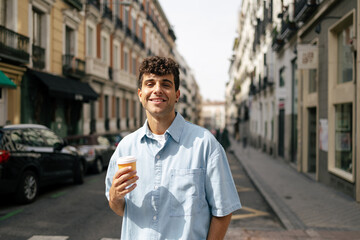 Young man in the street with a cup of coffee