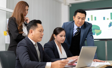 Business mentor meeting with team in office looking at computer screen training management concept. Asian businessman work together with executive colleague group talking mentoring leadership idea.