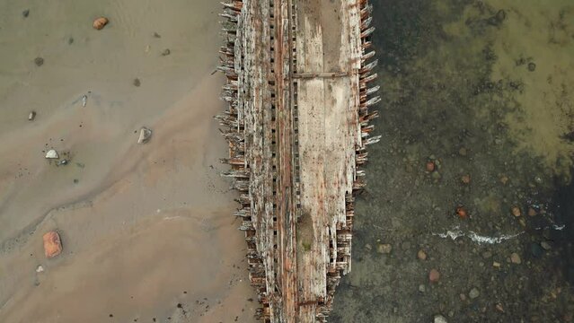 Abandoned shipwreck, An abandoned broken boat full of holes lying on the seashore. Wreck ship on reefs in sea or ocean. The sunken ship, the ship ran aground. Ecological disaster of the Aral Sea.