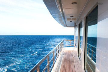 The outdoor deck of a luxury yacht that is underway at sea.