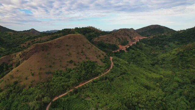 Drone footage of Philippines Mountains. We can see beautiful green and yellow mountains or hills sourrounded by endless sea.