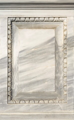 An empty flat surface of white marble with an ornamental frame. Blank vintage background with a square shape from a monument to include a text or image