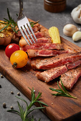 Filet mignon on tabletop on rocky background(Rosemary, garlic, butter, pepper, salt and other spices),close up