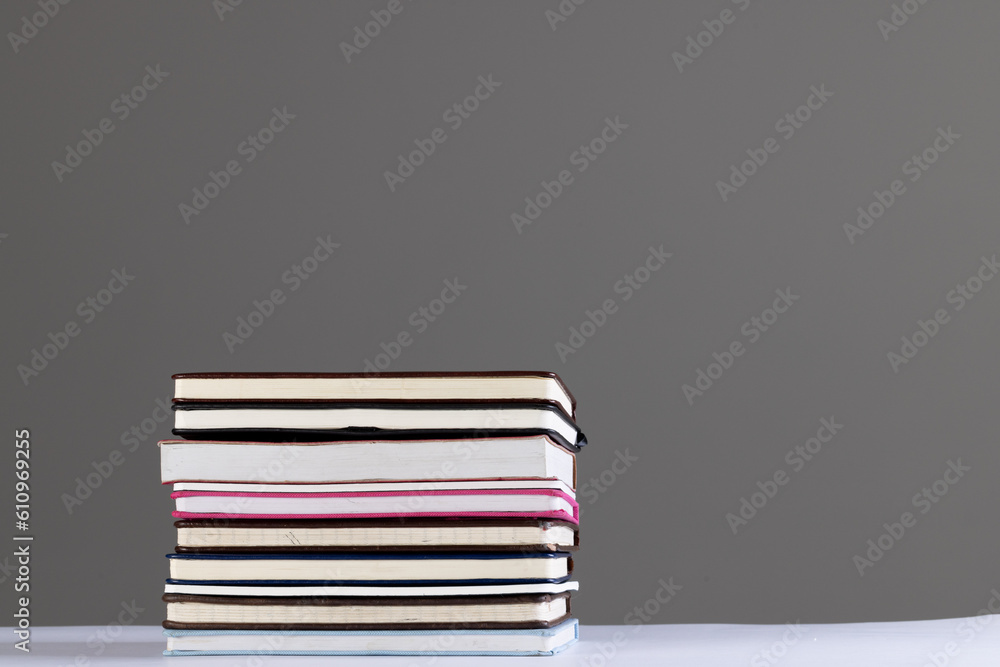 Poster close up of stack of books and notebooks with copy space on grey background