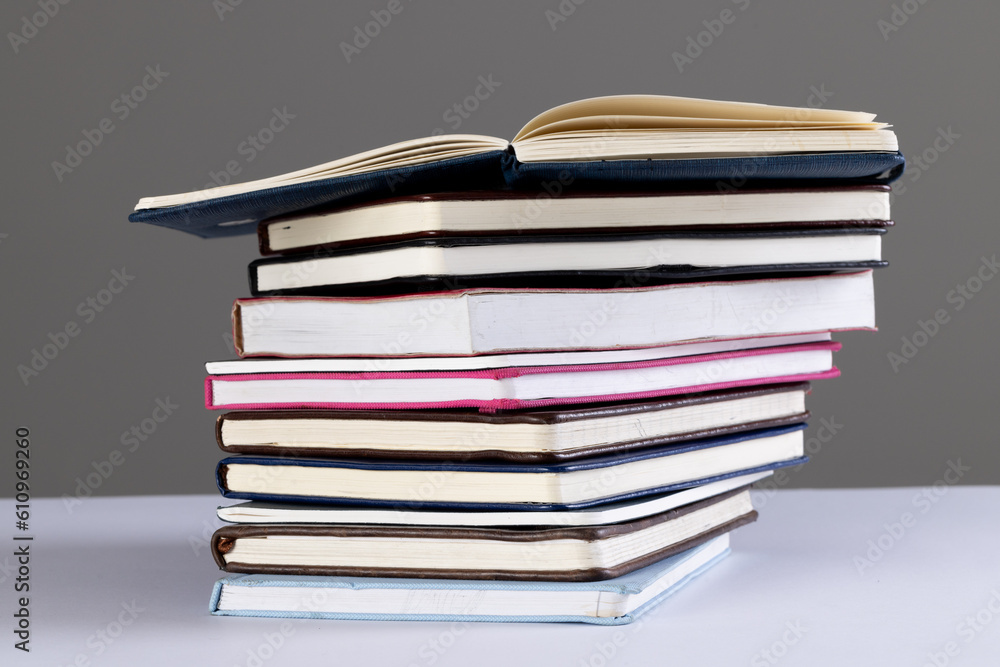 Poster close up of stack of books and notebooks with copy space on grey background