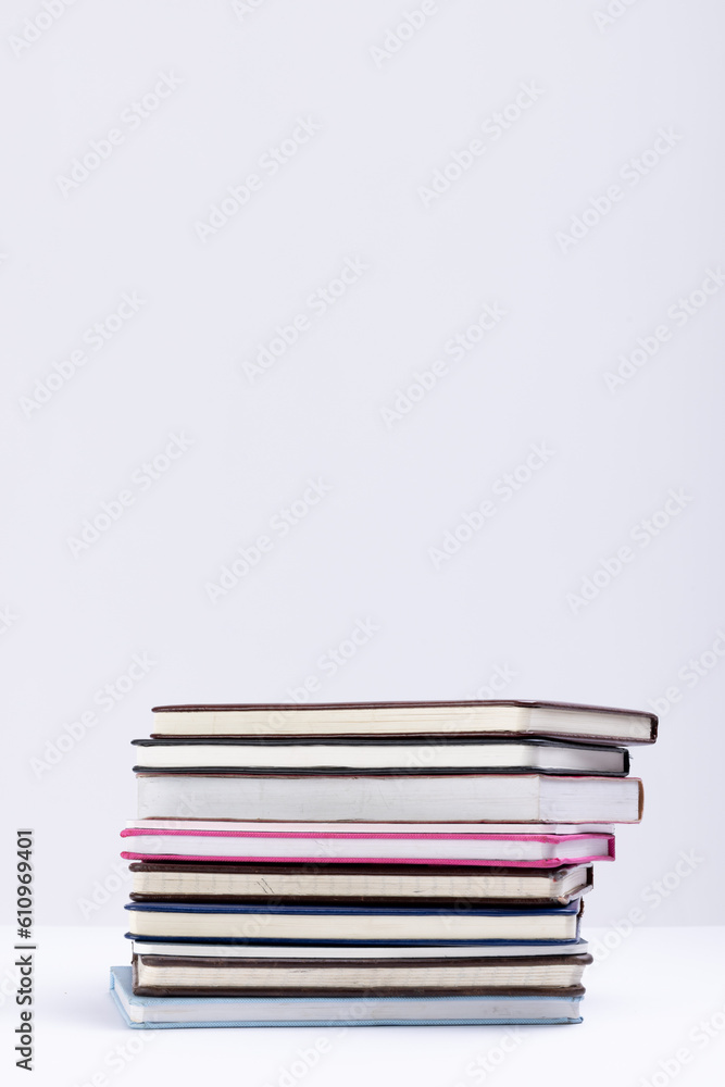 Poster close up of stack of books and notebooks with copy space on white background