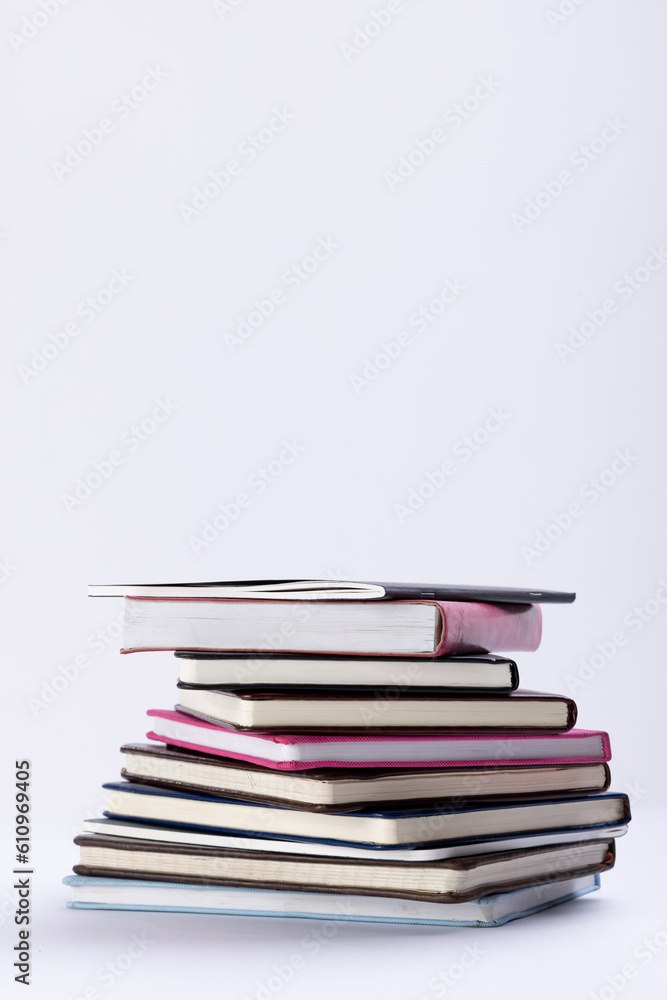 Poster close up of stack of books and notebooks with copy space on white background