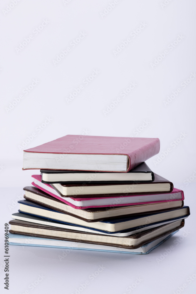 Poster close up of stack of books and notebooks with copy space on white background