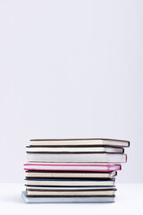 Close up of stack of books and notebooks with copy space on white background