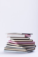 Close up of stack of books and notebooks with copy space on white background