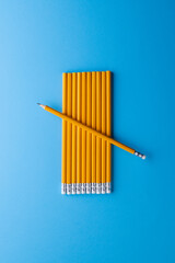 Close up of yellow pencils with erasers and copy space on blue background