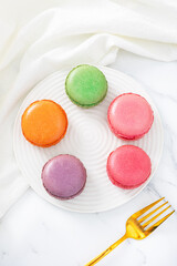 Colorful macaron cakes with cream filling on a table indoors, close-up