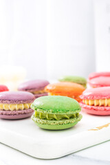 Colorful macaron cakes with cream filling on a table indoors, close-up