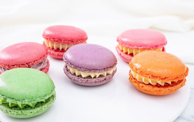 Colorful macaron cakes with cream filling on a table indoors, close-up