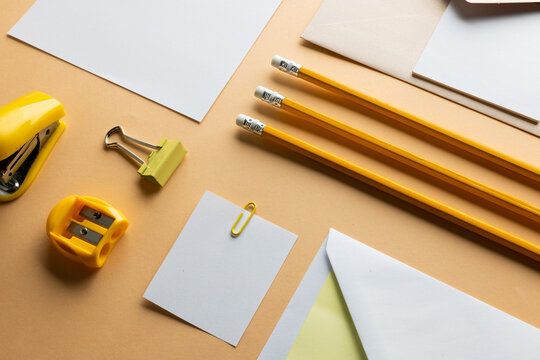 Flat lay of yellow pencils, sharpener and white paper with copy space on yellow background