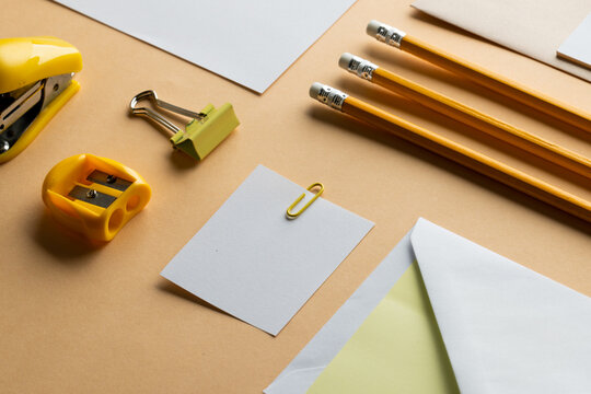 Flat lay of yellow pencils, sharpener and white paper with copy space on yellow background