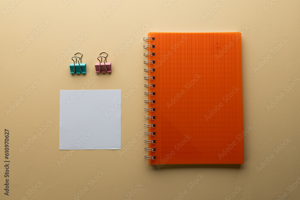 Aufkleber flat lay of orange notebook, memo note and paper clips with copy space on yellow background