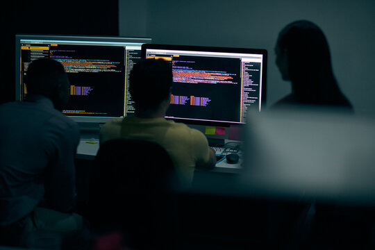 Programming, code and computer with business people in office at night for cyber security, cloud computing and data. Software development, teamwork and digital with developers for coding and network