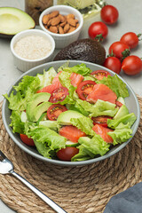 Vegetable salad with fish,  tomatoes, avocado and cucumber on a gray background