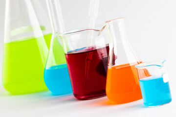 Close up of chemistry beakers and dishes with liquid and copy space on white background