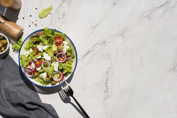Greek salad with vegetables and cheese on a gray table
