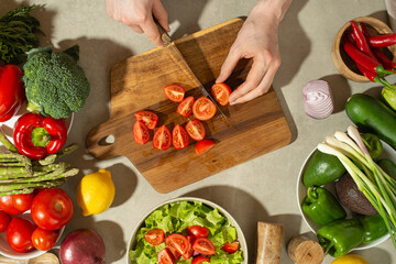 A man prepares a vegetable salad with a whole apron, close-up